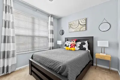 a bedroom with a bed with a stuffed animal on it at The Wish House, just miles from Disney World in Orlando