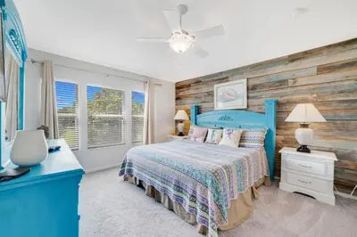 a bedroom with a blue bed and a wooden wall at Windsor Hills Townhome in Orlando