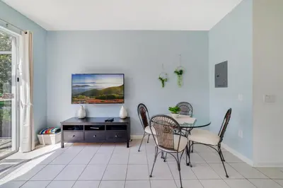 a dining room with a table and chairs and a tv at Windsor Hills Townhome in Orlando