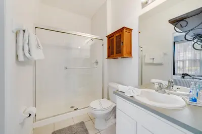 a white bathroom with a toilet and a shower at Windsor Hills Townhome in Orlando