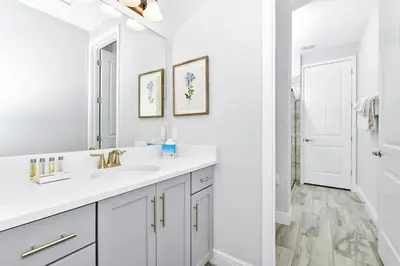 a white bathroom with a sink and a mirror at Elite Home Near Disney With Theater Room, Game Room And Private Pool With Water Park Access At Encore Resorts Reunion - 200Au in Kissimmee