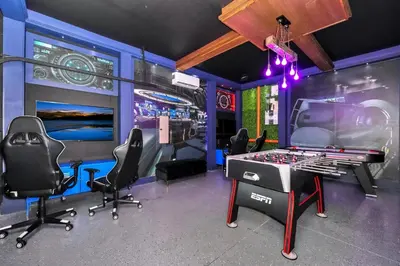 a video game room with a game table and chairs at Elite Home Near Disney With Theater Room, Game Room And Private Pool With Water Park Access At Encore Resorts Reunion - 200Au in Kissimmee