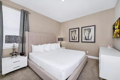 a bedroom with a large white bed and a window at Elite Home Near Disney With Theater Room, Game Room And Private Pool With Water Park Access At Encore Resorts Reunion - 200Au in Kissimmee