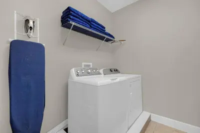 a laundry room with a washing machine and a blue towel at 541 Villa- 7BD Dream Home - Private PoolSpa in Orlando