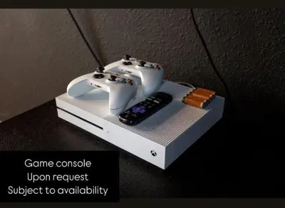 a video game console and a remote control on a table at 541 Villa- 7BD Dream Home - Private PoolSpa in Orlando