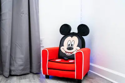 a cartoon mickey sitting in a red chair at Your Orlando home 15 min to Disney - KGG01 in Kissimmee