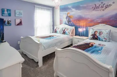 a bedroom with two beds and a painting on the wall at Luxury 9BR Villa @ Storey Lake Resort Near Disney in Kissimmee