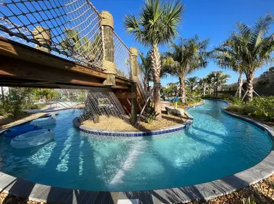 a bridge over a swimming pool with palm trees at Amazing 6BR Villa @ Storey Lake Resort Near Disney in Kissimmee