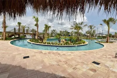 a large pool with palm trees in a resort at Amazing 6BR Villa @ Storey Lake Resort Near Disney in Kissimmee