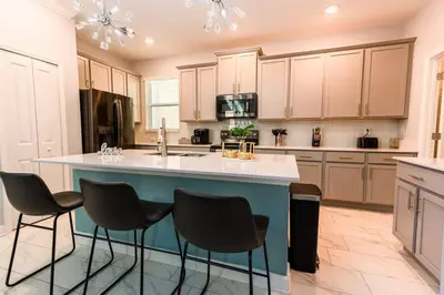 a large kitchen with a blue island in the middle at Modern Adventure Home near to Disney in Kissimmee
