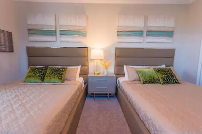 a bedroom with two beds and a table with a lamp at Modern Adventure Home near to Disney in Kissimmee