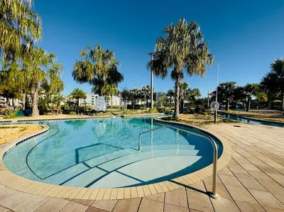 a swimming pool in a park with palm trees at Magical Themed Home - Disney 15 min in Kissimmee