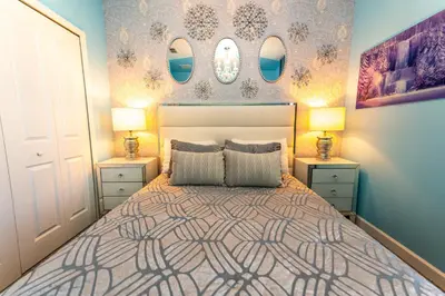 a bedroom with a bed with two night stands and two lamps at 6BR Disney Oasis with Pool, Game Room and Resort in Kissimmee
