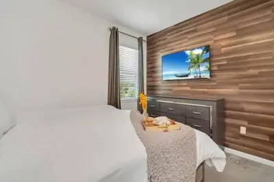 a bedroom with a bed and a tv on a wall at Serene Sunsets Villa - E04 in Kissimmee