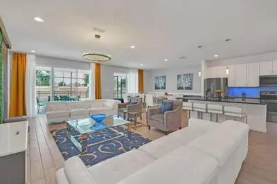 a living room with a white couch and a kitchen at Serene Sunsets Villa - E04 in Kissimmee