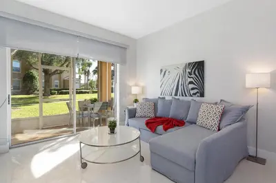 a living room with a blue couch and a glass table at One in a Minion #102 in Orlando