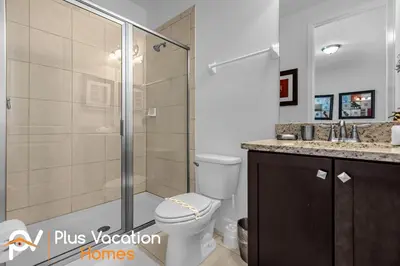 a bathroom with a toilet and a glass shower at 7594 Oasis 8BD Villa- poolspa in Orlando