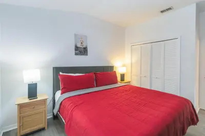 a bedroom with a large red bed with two lamps at Huge Screened Patio That Overlooks Lake Buck, Near Famous Attractions!! in Orlando