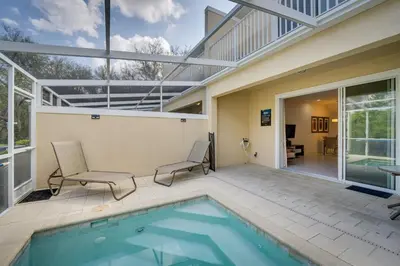 a swimming pool with two chairs and a house at Townhome with Lanai about 9 Mi to Disney! in Orlando