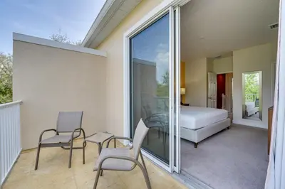 a room with a balcony with a bed and chairs at Townhome with Lanai about 9 Mi to Disney! in Orlando