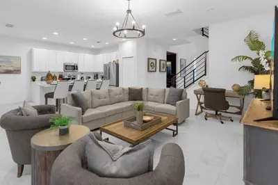 a living room with couches and chairs and a kitchen at 5BR Family Home with Pool & Hot Tub Near Disney in Kissimmee