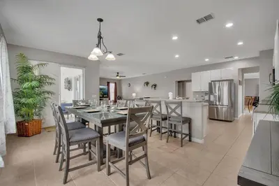 a dining room and kitchen with a table and chairs at 6 Bedroom Luxury Pool Home, Ensuite Bathrooms in Kissimmee