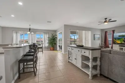 a kitchen and living room with a bar and a couch at 6 Bedroom Luxury Pool Home, Ensuite Bathrooms in Kissimmee