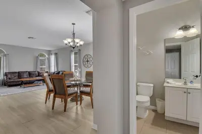 a dining room and living room with a table and chairs at 6 Bedroom Luxury Pool Home, Ensuite Bathrooms in Kissimmee