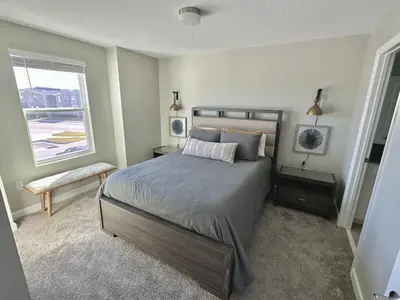 a bedroom with a large bed and a window at Amazing 6br w pvt pool game room near Disney in Kissimmee