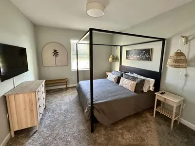 a bedroom with a canopy bed and a television at Amazing 6br w pvt pool game room near Disney in Kissimmee