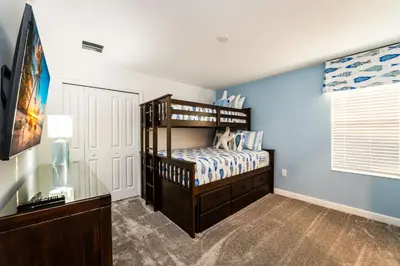 a bedroom with a bunk bed and blue walls at Amazing 8br w pool theater game room by Disney in Kissimmee