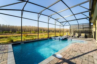an indoor swimming pool with a glass roof at Amazing 8br w pool theater game room by Disney in Kissimmee