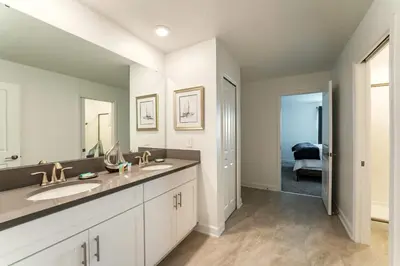 a bathroom with two sinks and a large mirror at Amazing 8br villa w theme rms game room theater in Kissimmee