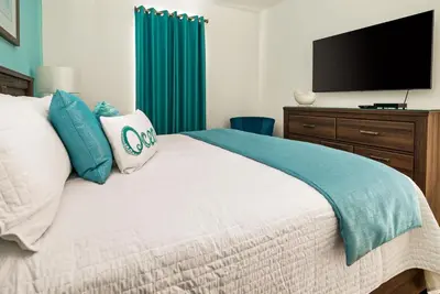 a bedroom with a bed with a flat screen tv at Awesome new 8br w theme rooms theater by Disney in Kissimmee