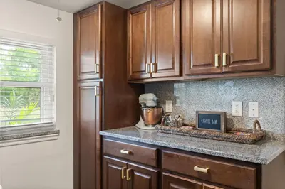 a kitchen with wooden cabinets and a mixer on a counter at Luxury Home, Workspace, Movie Room and BBQ in Kissimmee