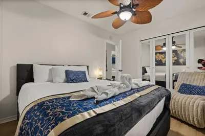a bedroom with a bed with a ceiling fan at Luxury Home, Workspace, Movie Room and BBQ in Kissimmee