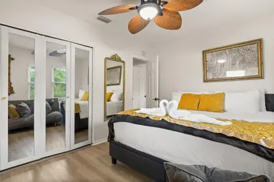 a bedroom with a bed with a ceiling fan at Luxury Home, Workspace, Movie Room and BBQ in Kissimmee