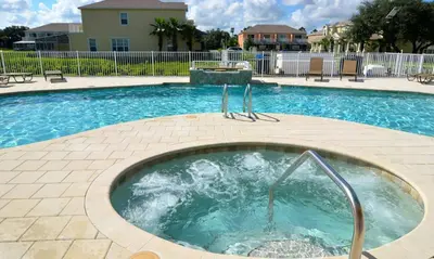 a swimming pool with a hot tub in the middle at Serenity 3 Bed 3 Bath Townhome With Pool, Private Balcony, Clubhouse, Communal Pool, Conservation View, Disney 15 Mins By Orlando Holiday Rental, in Orlando