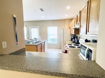 a kitchen with a counter top and a refrigerator at Lakeside Community, Pools, And More! in Kissimmee