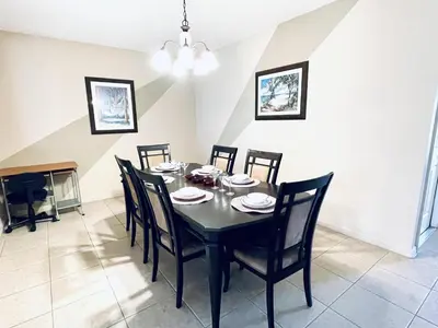 a dining room with a black table and chairs at Lakeside Community, Pools, And More! in Kissimmee