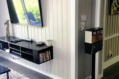 a room with a television and a shelf with books at Beautiful cottage near Lake Louisa & mins from Disney, Vehicle Rental Available in Clermont