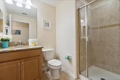 a bathroom with a shower and a toilet and a sink at Amazing 5BD and 4BH 6 miles from Disney in Kissimmee