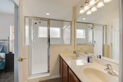 a bathroom with a shower and a sink and a mirror at Large Pool Deck * All Rooms w/ Private Bathroom in Kissimmee