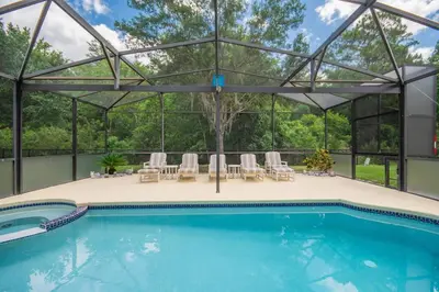 a pool with a pavilion with chairs and a swimming pool at Large Pool Deck * All Rooms w/ Private Bathroom in Kissimmee