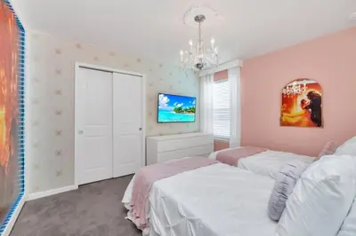 a bedroom with two beds and a tv at Many Themes For Everyone 10 Huge Bedrooms! villa in Kissimmee