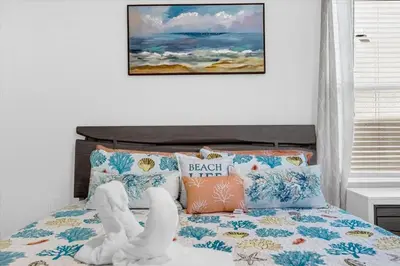 a bedroom with a bed with a headboard and pillows at Stylish Resort Villa w Pool Near Disney Gated 5BR in Kissimmee