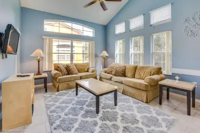 a living room with two couches and a tv at 2739SKP New Emerald Island 4 Bedroom townhouse in Kissimmee