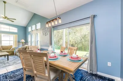 a dining room with a wooden table and chairs at 2739SKP New Emerald Island 4 Bedroom townhouse in Kissimmee
