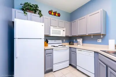a kitchen with white appliances and blue walls at 2739SKP New Emerald Island 4 Bedroom townhouse in Kissimmee