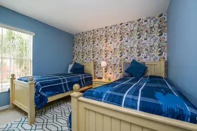 a bedroom with two beds and blue walls at 2739SKP New Emerald Island 4 Bedroom townhouse in Kissimmee